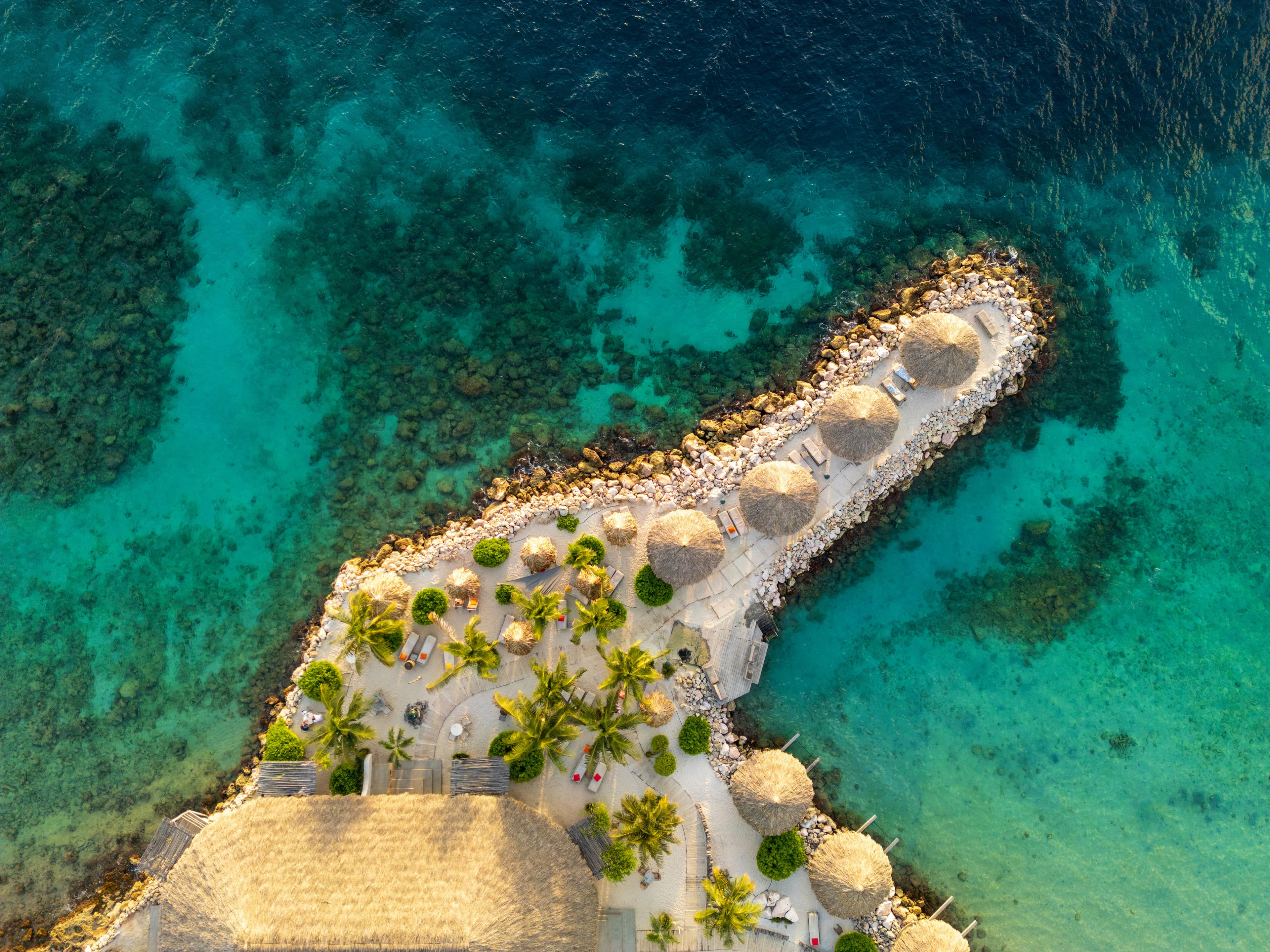 Aerial view of a tropical resort island surrounded by turquoise water in Curaçao